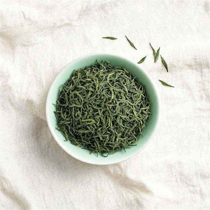 Loose-leaf Mao Feng green tea in a celadon bowl